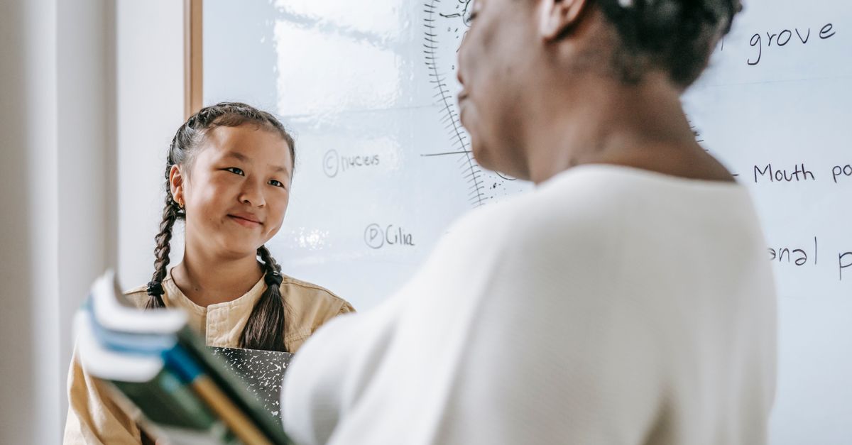 Teacher explaining pronunciation to a student in a classroom setting