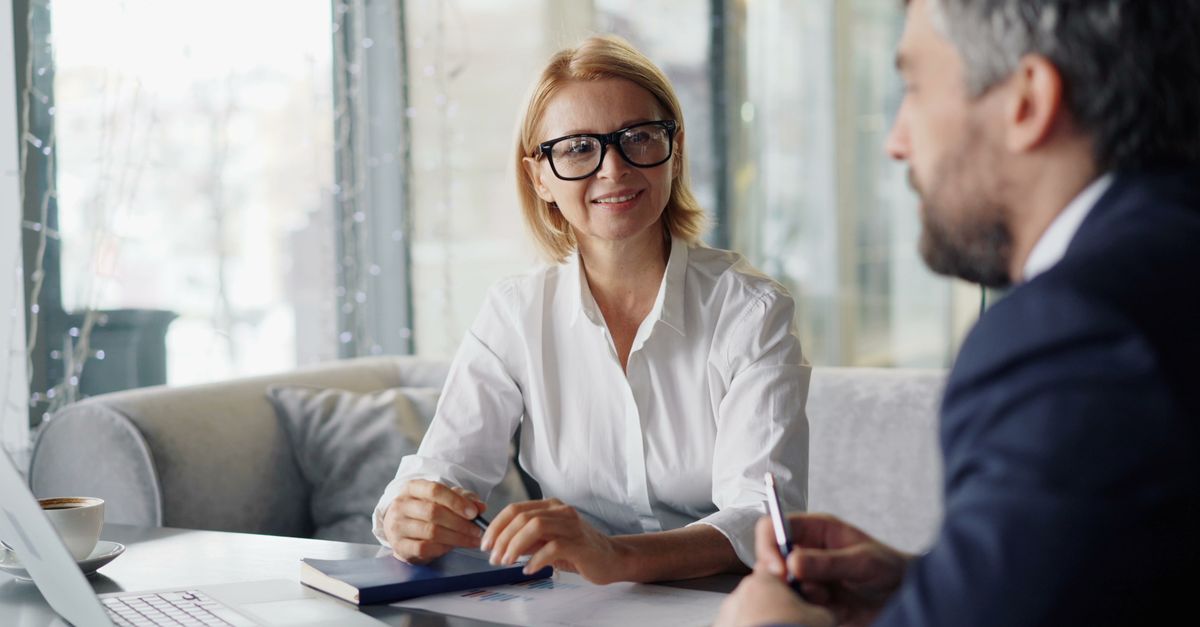 Two business professionals having a conversation in a modern office