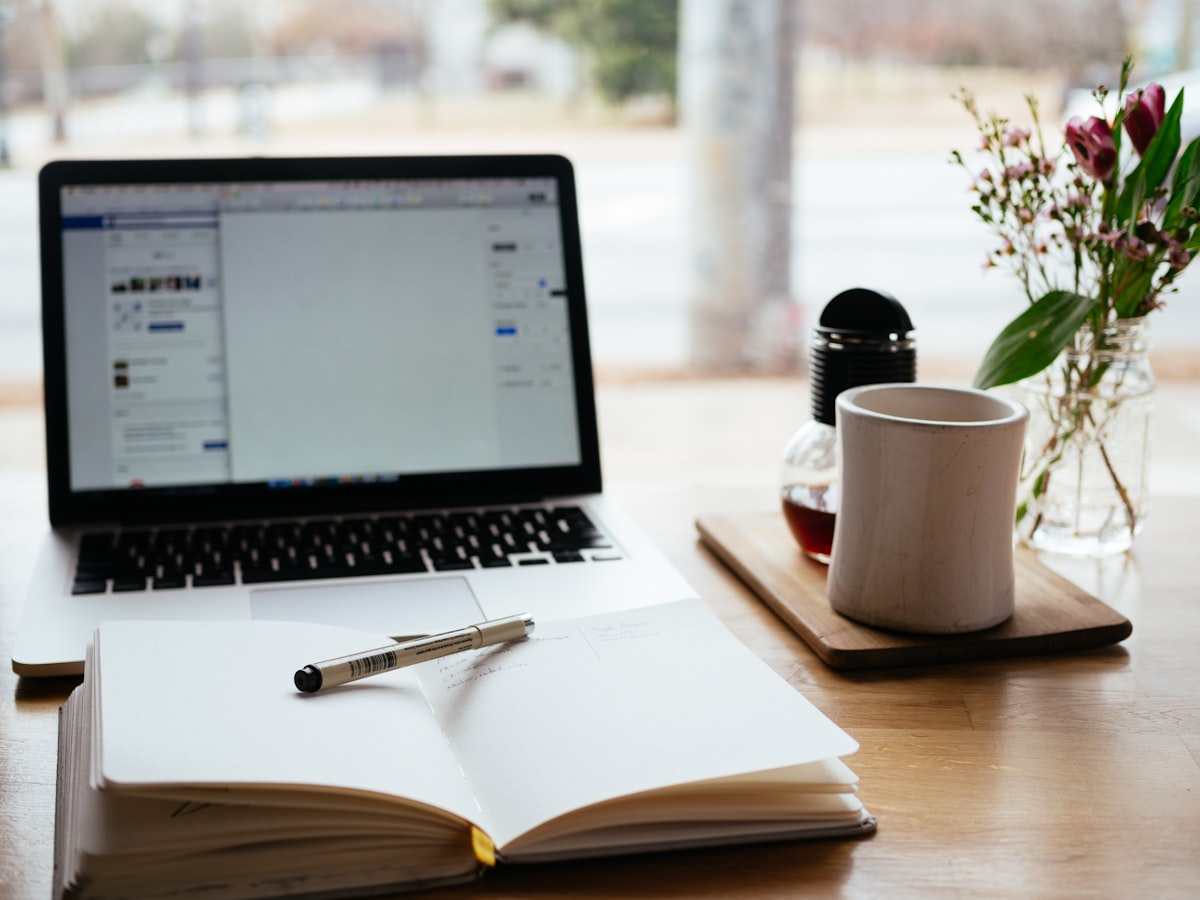 Laptop and open notebook on a desk for study and note-taking